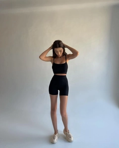 Detail shot of black ribbed yoga set featuring a strappy crop top and high waist shorts