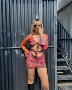 Detail of sheer mesh tie-front top with vibrant red and orange abstract tie-dye patterns
