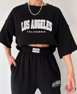 Detailed close-up of white Los Angeles print and brand label on black cotton set