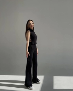 Detail view of black ribbed knit set featuring side lace-up top and wide-leg trousers