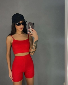 Detail of red ribbed knit two-piece set featuring thin straps and matching biker shorts
