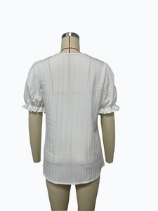 Close-up back view of white short sleeve blouse with vertical stripes and ruffle cuffs