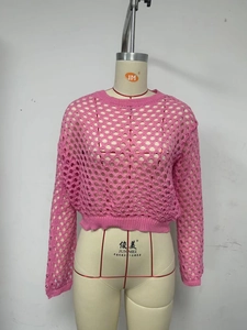 Detail of pink knit sweater featuring crochet hollow-out pattern and ribbed round neckline