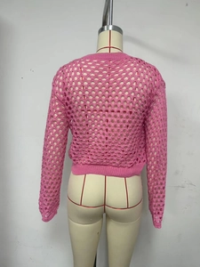 Close-up of pink crochet knit hollow-out sweater with textured mesh pattern