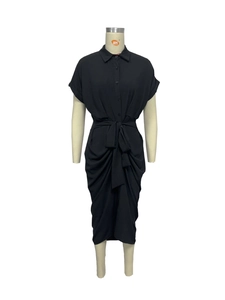 Détail d'une robe chemise noire à manches courtes avec col boutonné et ceinture nouée