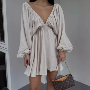 Elegant champagne V-neck mini dress with long puff sleeves and smooth satin finish