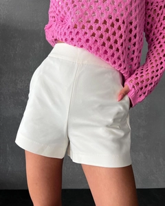Close-up detail of white high-waisted shorts with side pockets and smooth polyester fabric