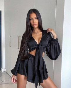 Detailed view of black satin long sleeve tie-front crop top and matching shorts set