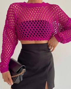 Close-up detail of rose red crochet knit texture and oversized mesh hollow-out pattern