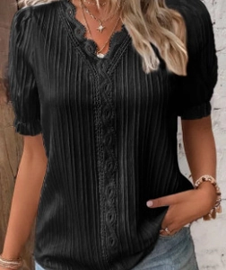 Detail of V-neck crochet lace trim and textured vertical pleats on a black blouse