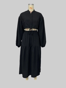 Detail view of black long-sleeved tie-up top and pleated split midi skirt set
