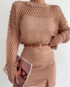 Detailed view of beige hollow-out crochet knit top with elegant high-slit midi skirt
