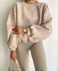 Detalle del tejido acanalado en los leggings beige y el puño de la sudadera a juego