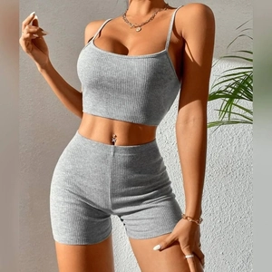 Women's grey ribbed two-piece yoga set featuring a crop top and high-waist slim shorts