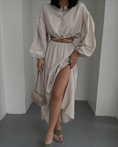 Detail of beige tie-waist long sleeve crop top and high slit maxi skirt two-piece set