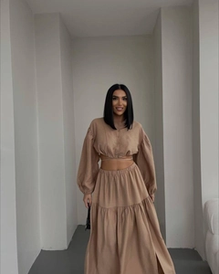 Detail of camel long-sleeve crop top and high-waist maxi skirt two-piece set