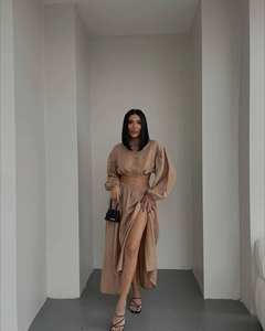 Detail of khaki two-piece set featuring long-sleeved tie-front top and side slit maxi skirt