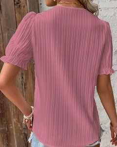 Detail of pink hollow-out short sleeves with ruffled cuffs and vertical ribbed texture