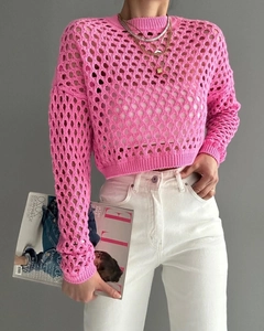 Detailed close-up of bright pink crochet knit texture and hollow diamond pattern sweater