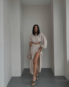 Detail of beige tie-front long sleeve top and high-slit skirt in linen texture