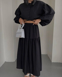 Detail of black long-sleeve crop top and pleated maxi skirt set with waist tie detail