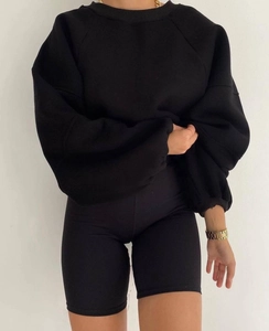 Detalle del conjunto de sudadera negra extragrande y pantalones cortos de ciclista