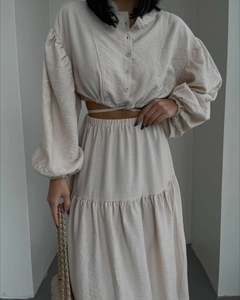 Detail of beige lantern sleeve top and high waist tiered maxi skirt with subtle texture