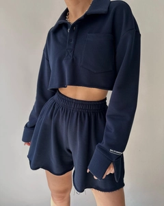Detail of navy blue two-piece lounge set with MAI STUDIOS CO embroidery on sleeve cuff