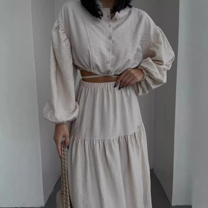 Elegant two-piece set with lantern sleeve tie-up top and pleated maxi skirt in cream beige