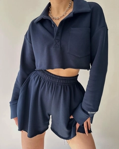 Detail of navy blue two-piece lounge set showing raw hem shorts and polo collar sweatshirt