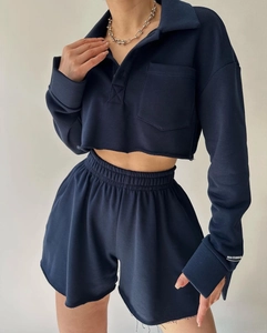 Detail of navy casual set featuring cropped long sleeve polo top with raw hem design