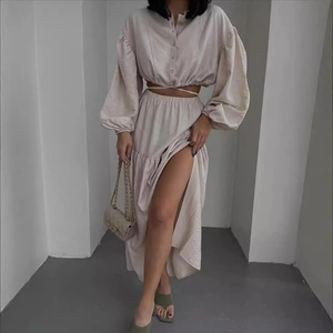 Elegant off-white two-piece set featuring a tie-up lantern sleeve top and slit maxi skirt