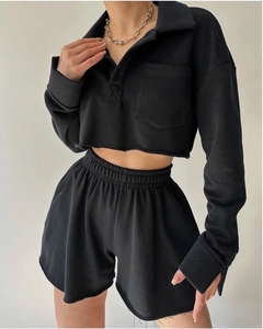 Detail of black long sleeve crop polo top and high waist shorts with raw cut edges