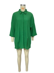 Detail of green longline shirt with crepe texture, split hem and half-placket design