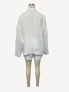 Detail view of the back of white long-sleeve crinkle fabric shirt and shorts set