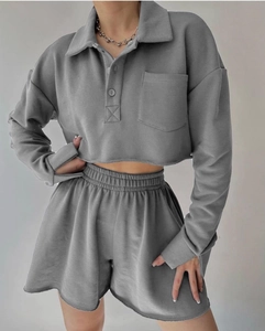 Detail of grey cropped long-sleeve polo sweatshirt with chest pocket and matching shorts