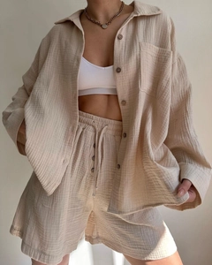Detailed texture of beige crinkled fabric on a long sleeve shirt and drawstring shorts set