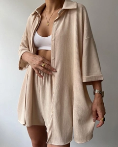 Close-up of beige textured fabric on two-piece set featuring split sleeves and shorts