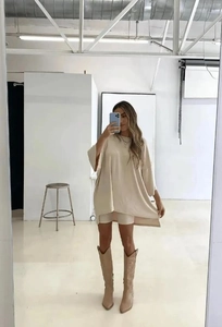 Detail of loose beige oversized t-shirt and matching slim shorts with denim boots