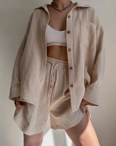 Detail of beige crinkle fabric shirt and high waist drawstring shorts casual set
