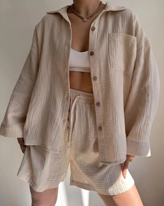 Detailed texture of beige muslin crepe shirt and drawstring shorts on model