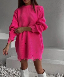 Close-up of distressed ripped details and frayed hem on oversized neon pink knit sweater