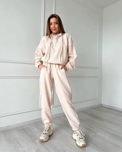Detail of pink corduroy long sleeve hooded tracksuit set for women in minimalist room