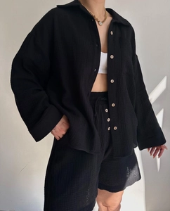 Detail of black crinkle fabric texture on casual shirt and drawstring shorts set