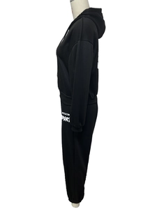 Détail d'un survêtement noir avec imprimé lettres sur le pantalon et poignets côtelés