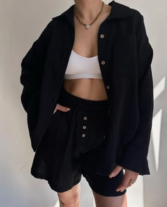 Detail of black long sleeve shirt and shorts set with textured fabric and buttons