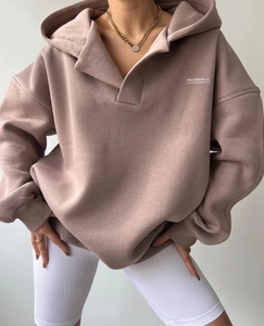 Détail du sweat à capuche rose avec logo MAI STUDIOS CO. et texture en polaire douce