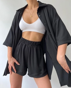 Detail shot of black textured split-sleeve shirt and high-waist shorts set for women