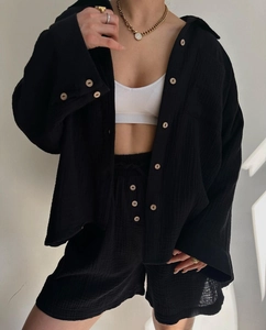 Detailed texture of black crinkle fabric two-piece set with natural wood buttons