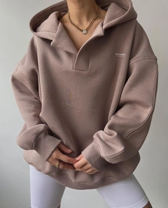 Détail du sweat à capuche rose poudré avec épaules tombantes et logo MAI STUDIOS